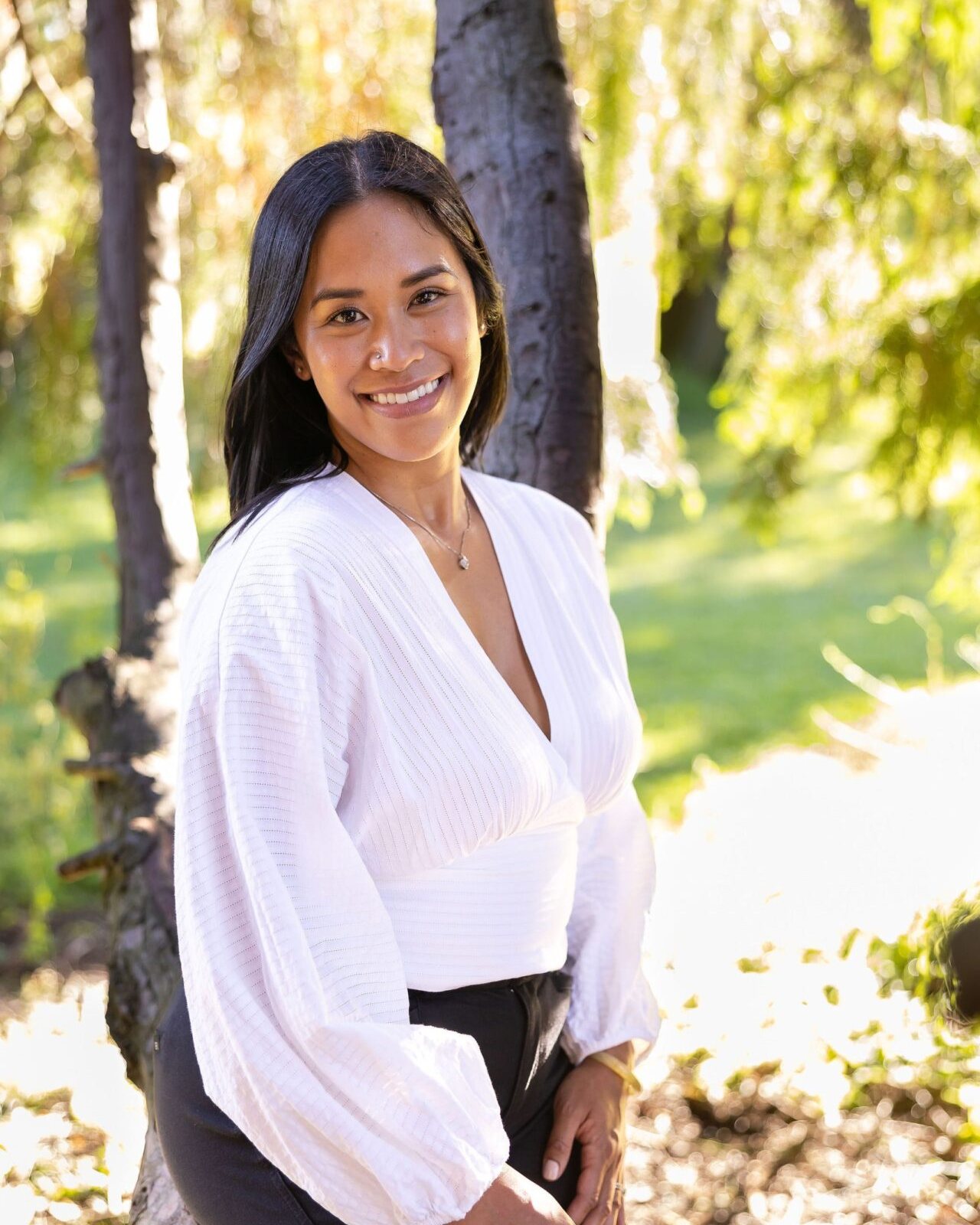 Dr. Monee Dulay smiling by a tree outdoors