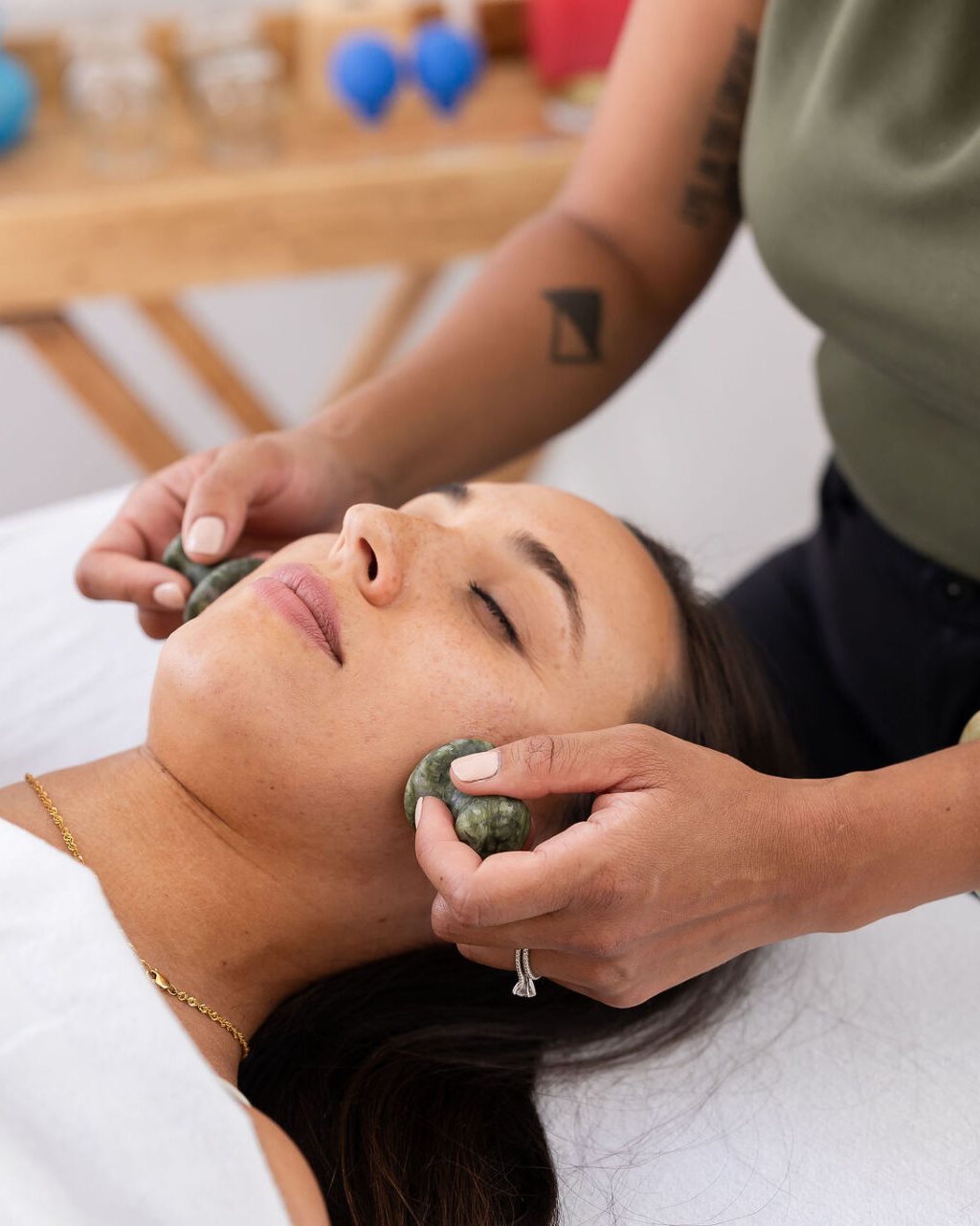 Dr. Monee giving a facial gua sha treatment with jade stones