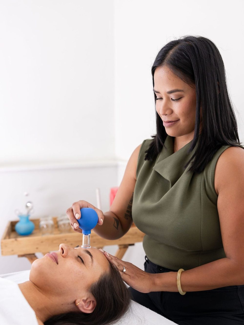 Dr. Monee preparing a cupping treatment for a client